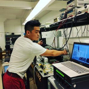 Kyle Hsu in a lab with electronic equipment