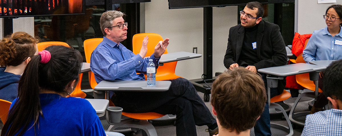 alumnus and students interacting at a fireside chat