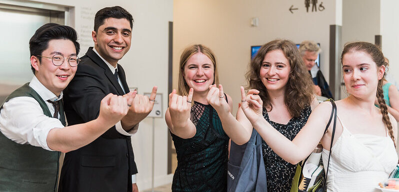 photo of five students showing off their iron rings to the camera at the EngSci Convocation Reception 2022