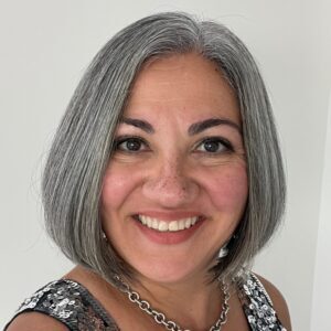 photo of Leila Kheradpir smiling to camera, wearing a sleeveless top